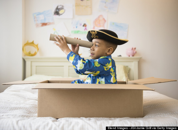 African American boy playing in cardboard box
